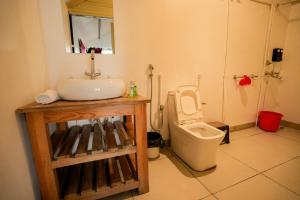 a bathroom with a sink and a toilet at The Hillside Cottages in Kanatal