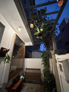 un porche con un banco y un techo con plantas en 巴摩蘇蘿 Bramasole, en Anping
