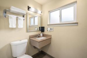 サンルイス・オビスポにあるAvenue Inn Downtown San Luis Obispoのバスルーム(トイレ、洗面台付)、窓が備わります。