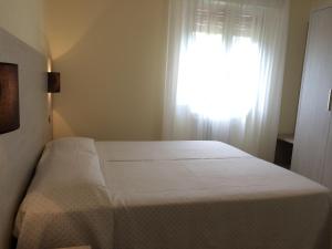 トッリ・デル・ベーナコにあるHotel Zanettiのベッドルーム1室(窓、白いベッド1台付)