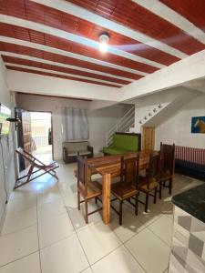 a living room with a wooden table and chairs at Residencial Praia Quente casas in Nova Viçosa