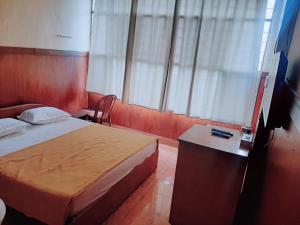 Habitación de hotel con cama, mesa y ventana en Vega Residency And Bike Rentals en Madikeri