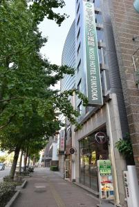 a building with a sign on the side of a street at Nissei Hotel Fukuoka in Fukuoka