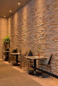 a brick wall with tables and chairs in a restaurant at Nissei Hotel Fukuoka in Fukuoka