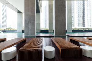 a large room with benches and tall buildings at ARCORIS, MONT KIARA by MK HOME in Kuala Lumpur