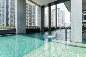 a pool with a fountain in a building with tall buildings at ARCORIS, MONT KIARA by MK HOME in Kuala Lumpur