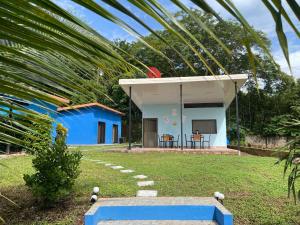 a blue and white house with a palm tree at POSADA MIRADIA in Matapalo