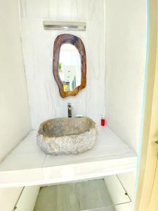 a bathroom with a stone sink and a mirror at Villa Oceana I - 3BR private villa with pool in Legian
