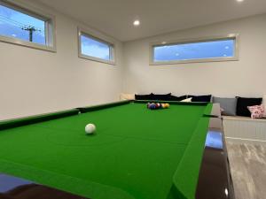 sala de estar con mesa de billar verde en PepperTree Farm Stay, en Grassy