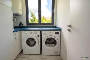 lavadero con lavadora y secadora y ventana en Villa Palm Diamond Jacuzzi & Piscine privés, en Le Diamant