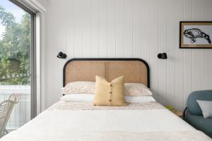 a bedroom with a bed with a large window at The Bunkie @ Ethel & Odes in Bundeena