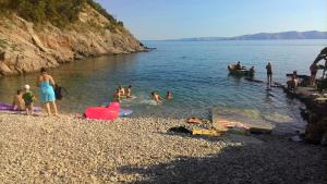 a group of people in the water at a beach at Apartment and Rooms Busa 3 in Senj