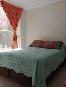 1 dormitorio con cama y ventana con cortina en Departamento nuevo 1D1B estacionamiento privado gratis en Viña del Mar