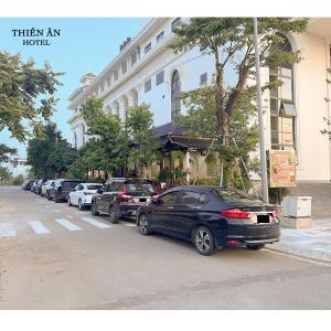 a row of cars parked in front of a building at Thiên Ân Hotel in Thôn Dương Phẩm