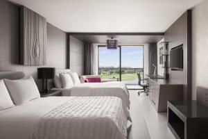 曼谷的住宿－曼谷素萬那普艾美高爾夫水療度假酒店，酒店客房设有两张床和电视。