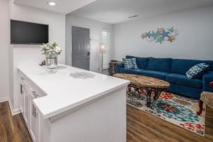 eine Küche und ein Wohnzimmer mit einem blauen Sofa in der Unterkunft Quick Escape, A Great Get Away! in Huntsville