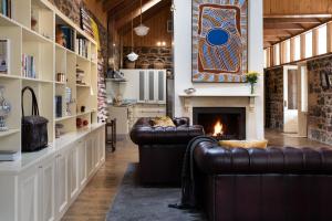 a living room with two leather couches and a fireplace at Orchards at Spring Vale Farm in Weatherboard