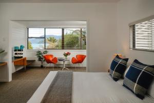 The Portage Resort في Portage: غرفة نوم بسرير وكرسيين برتقال