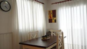 Un comedor con una mesa y sillas y un reloj. en EL RELOJ, en Chascomús