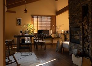 a living room with a table and chairs and a kitchen at Lodge Norheim in Asahikawa
