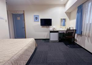 a hotel room with a bed and a desk at Nissei Hotel Fukuoka in Fukuoka