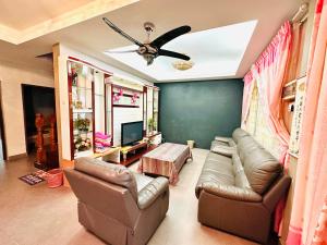 a living room with a couch and a ceiling fan at HM AIRBNB in Sibu