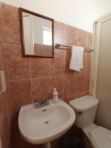 ein Badezimmer mit einem Waschbecken, einem WC und einem Spiegel in der Unterkunft Hospedaje La Gloria in Texcoco de Mora