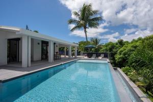 una piscina frente a una casa en Villa Palm Diamond Jacuzzi & Piscine privés, en Le Diamant