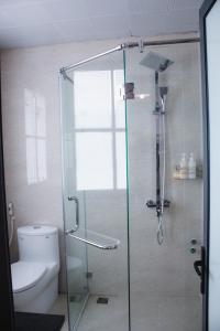 a bathroom with a glass shower with a toilet at AROMA Ha Long Hotel in Ha Long