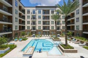 an apartment complex with a swimming pool and palm trees at Adorable 5star Luxury Living in Houston