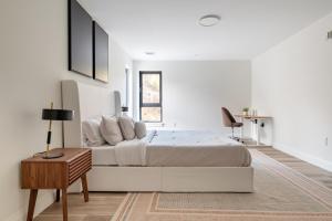 a white bedroom with a large bed and a table at Modern 2 Bedroom Apartment in Quincy in Quincy