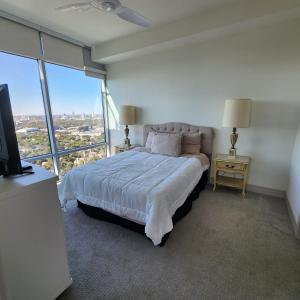 a bedroom with a bed and a large window at Latitude Med Center in Houston