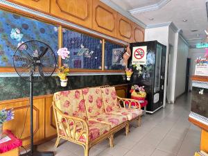 ein Zimmer mit Sofa und Ventilator in einem Geschäft in der Unterkunft Hotel Lutana in Sandakan