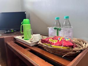 a table with a basket and two bottles of water at Hotel Lutana in Sandakan