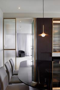 uma sala de jantar com uma mesa de vidro e cadeiras em Eos by SkyCity em Adelaide