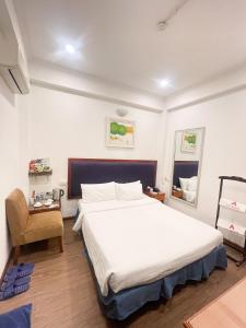 a bedroom with a large white bed and a chair at A25 Hotel - 30 An Dương in Hanoi