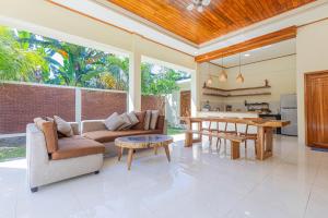 a living room with a couch and a table at Sandz House in Jembrana