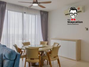 ein Esszimmer mit einem Tisch und Stühlen in der Unterkunft Staycation Homestay 30 Galacity Apartment Kuching in Kuching