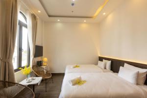 een hotelkamer met 2 bedden en een raam bij OLAGI HOTEL in Khu Chi Lăng