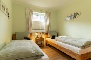 a bedroom with two beds and a window at FeWo Haus Friesenkind in Garding