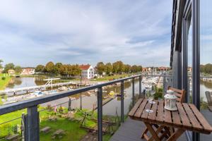 einen Tisch auf einem Balkon mit Flussblick in der Unterkunft Poller 23-Haus Alte Werft in Tönning