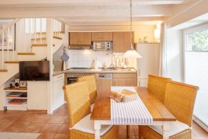eine Küche mit einem Holztisch mit Stühlen und einem Esszimmer in der Unterkunft FREESENHOFF Freesenhoff -EYLUND- in Langeoog