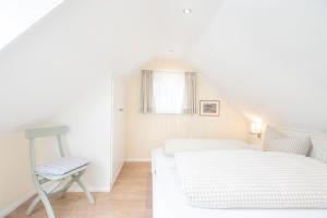 a small bedroom with a bed and a chair at FREESENHOFF Freesenhoff -EYLUND- in Langeoog