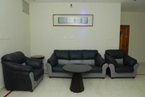 a living room with a couch and a table at Hill View Paradise Villa - duplex with private theater & 2bhk - A Golden Group Of Premium Home Stays - tirupati in Tirupati