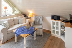 ein Wohnzimmer mit einem Sofa und einem Tisch in der Unterkunft FREESENHOFF Freesenhoff -OFDAK- in Langeoog