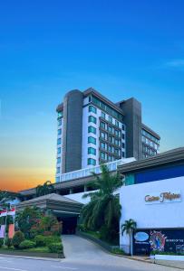 ein großes Gebäude mit Palmen davor in der Unterkunft Grand Regal Hotel Davao in Davao City