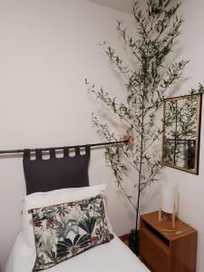 ein Schlafzimmer mit einem Bett mit einer Pflanze daneben in der Unterkunft appartamento PEACE&LAKE in Riva del Garda