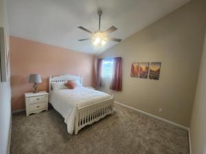 um quarto com uma cama branca e uma ventoinha de tecto em Loving Home away from home, 6 Bedrooms, 8 Beds em Colorado Springs