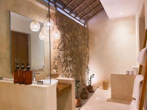 uma casa de banho com um lavatório e um espelho em Reset Lombok Hotel em Kuta