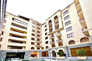 a largeartment building with a car parked in front of it at Byuzand 7 in Yerevan